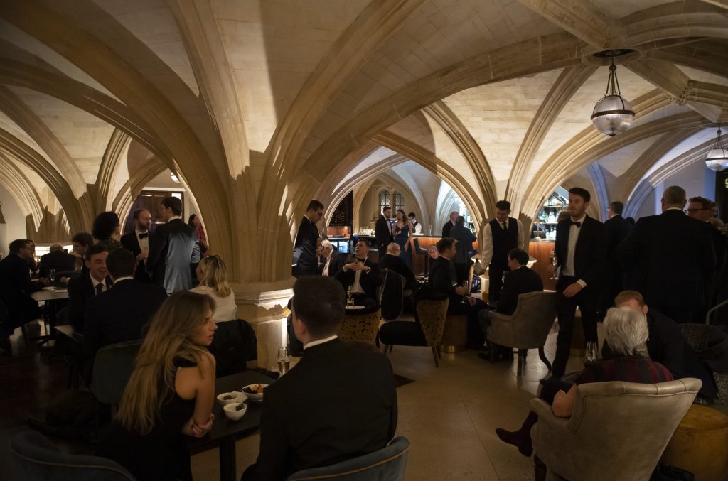Tables and chairs filled with guests at event in restaurant and bar with domed ceilings