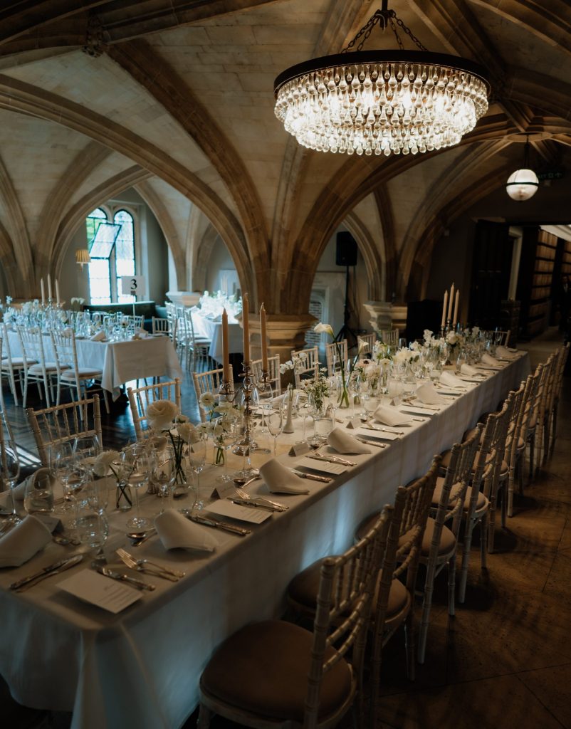 A wedding set up in the MCR with a centre table decorated in white linen and flowers.